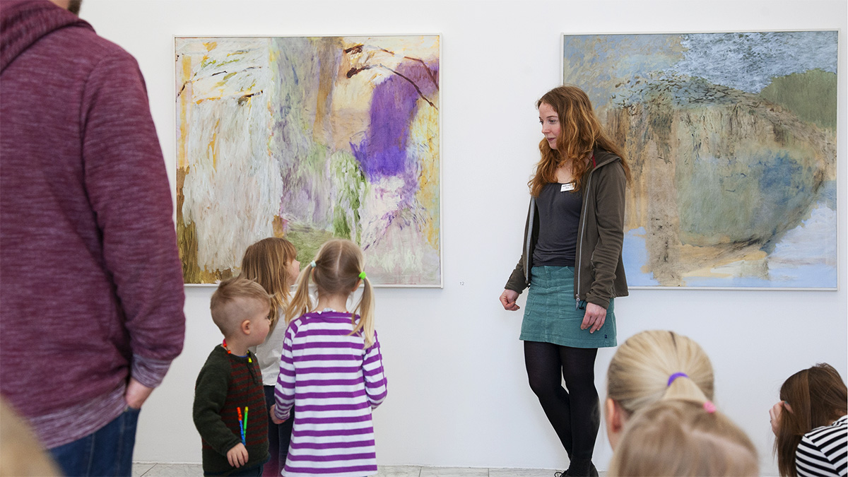 Barn och vuxna i konsthallen som tittar på konst tillsammans.